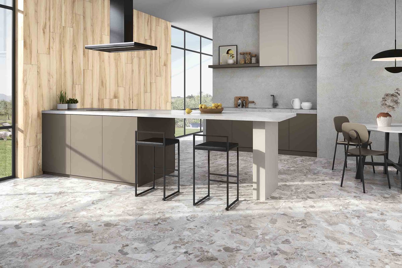 Bucătărie luminoasă, modernă, cu insulă de gătit, scaune de bar și pardoseală cu aspect de marmură