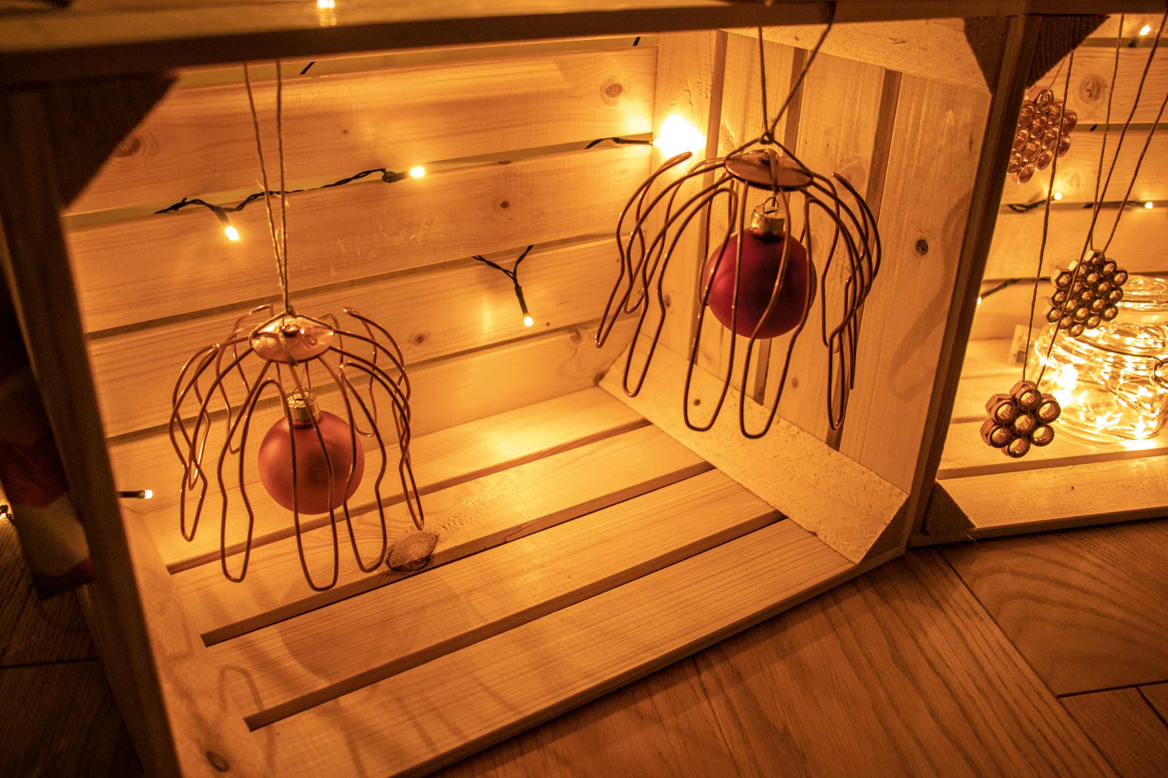Ladă decorativă din lemn cu globuri de pom și ghirlandă luminoasă pentru o atmosferă festivă
