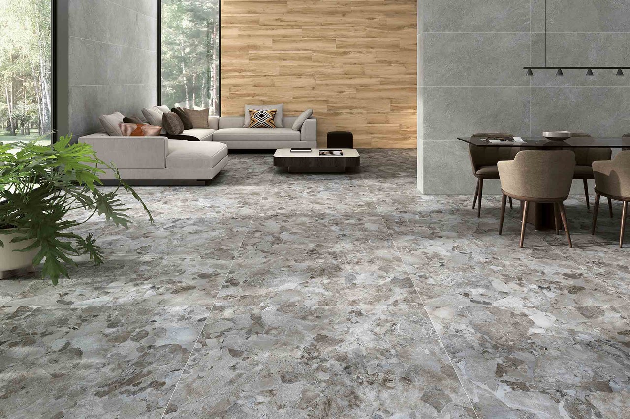 Cameră de zi luminoasă cu gresie cu aspect de marmură, canapea și masă de sufragerie.