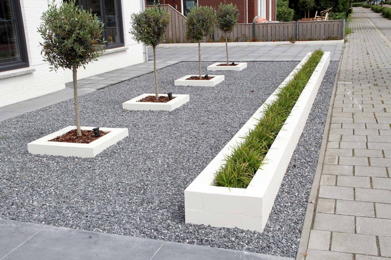 Grădină cu copaci în jardiniere pătrate, o jardinieră alungită și pietriș