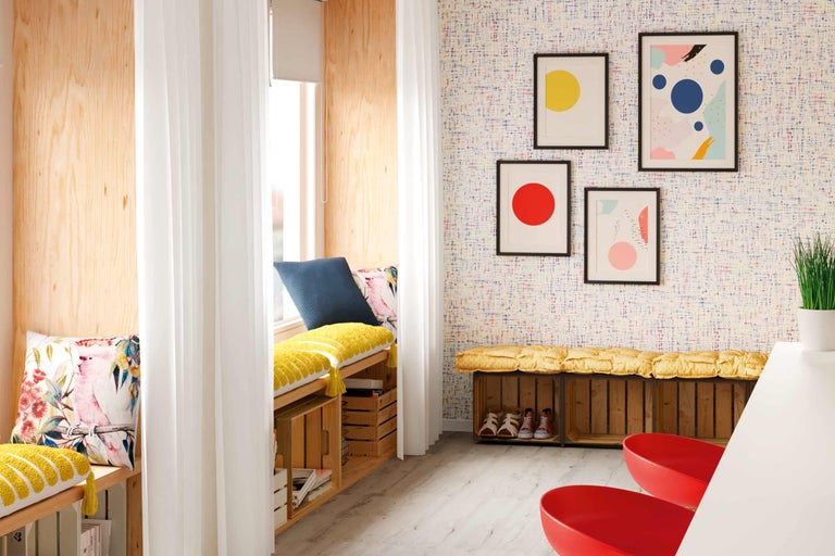 Colț de relaxare luminos, cu lambriuri din lemn, perdele, perne și decorațiuni de perete pentru o ambianță confortabilă.