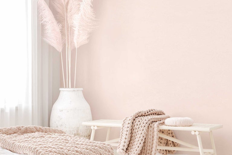 Design interior luminos cu bancă, pătură și vază cu iarbă de pampas