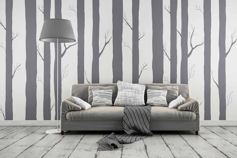 Cameră de zi cu canapea, perne, lampadar și tapet cu pădure pentru un ambient luminos și organizat.