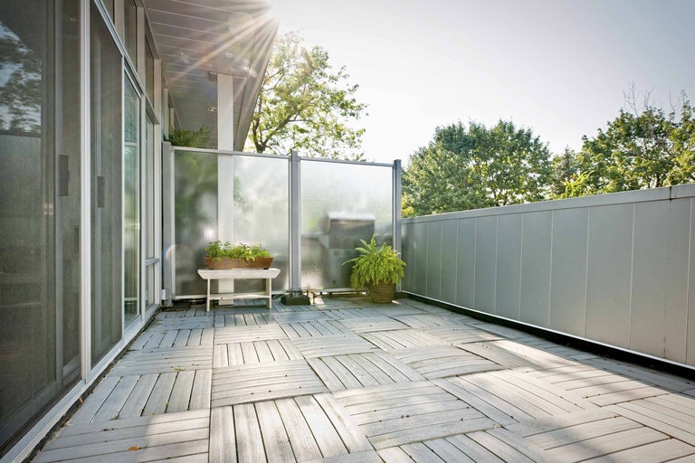 Balcon luminos cu plăci de lemn și paravan de intimitate