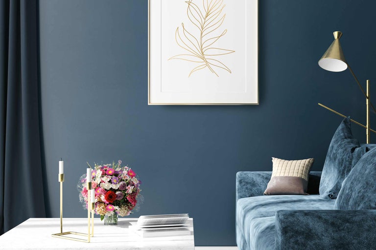 Scenă de living cu canapea, masă, vază cu flori, suport pentru lumânări și decorațiuni de perete