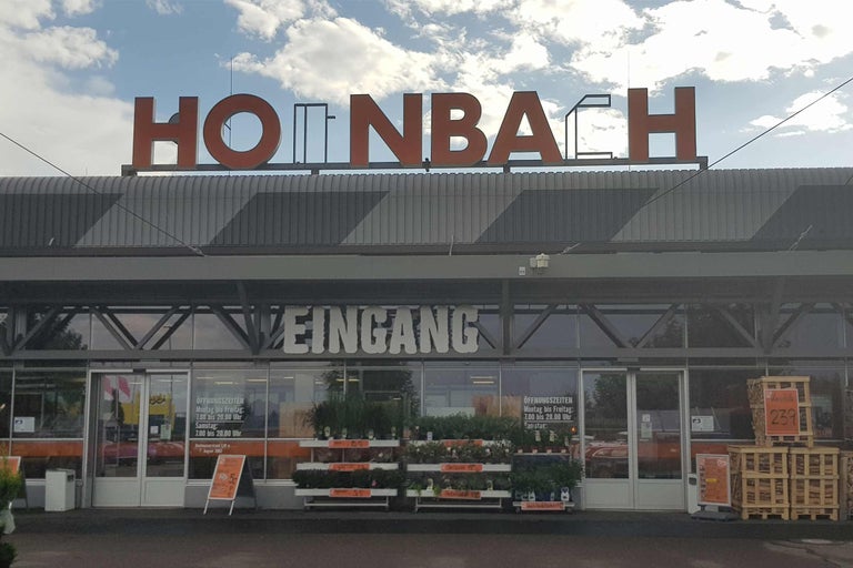 Fațada magazinului de bricolaj Hornbach cu intrare și expoziție de plante