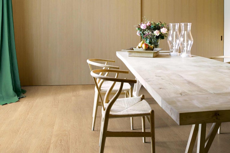 Zonă de luat masa luminoasă cu masă din lemn, scaune și decorațiuni