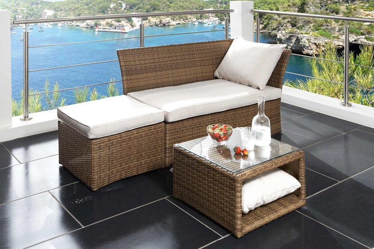 Terasa cu mobilier din ratan format dintr-o bancă, un taburet și o masă cu blat de sticlă