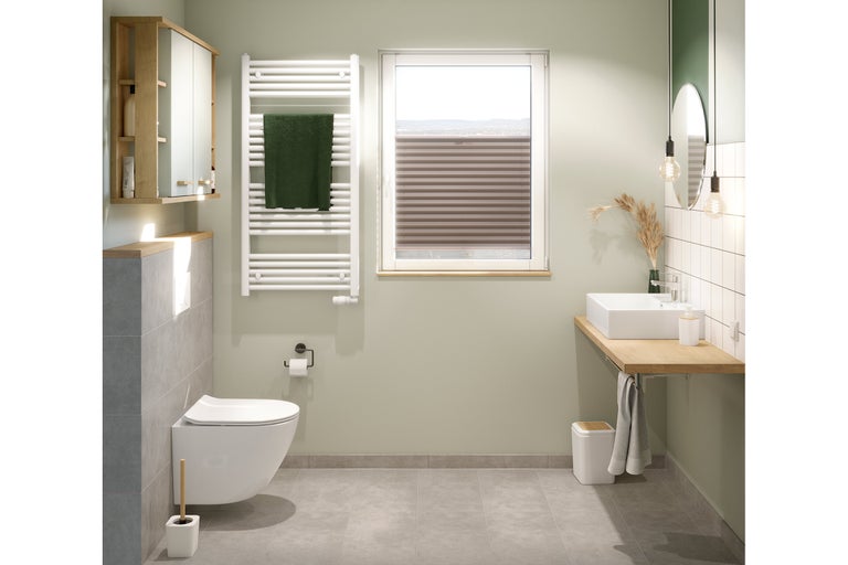 Baie modernă cu toaletă, chiuvetă, calorifer și dulap cu oglindă