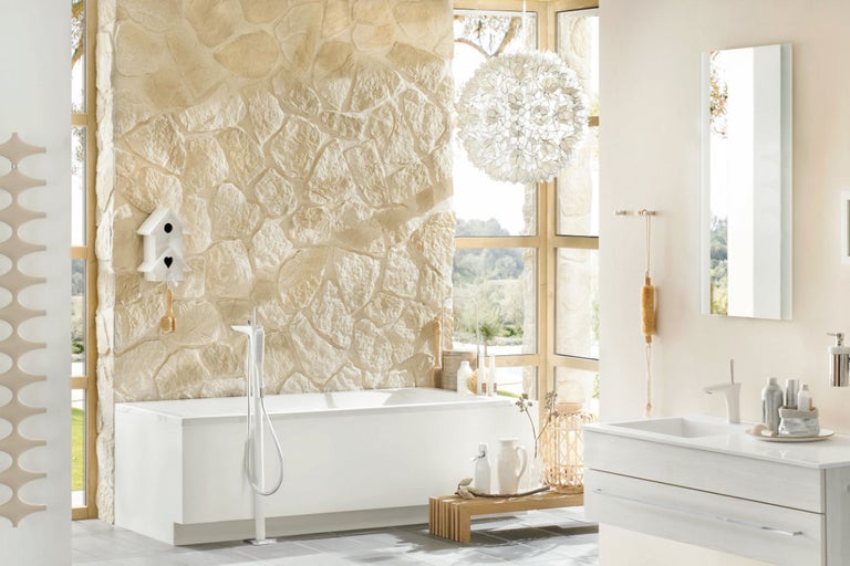 Baie luminoasă cu cadă, chiuvetă și perete din piatră naturală