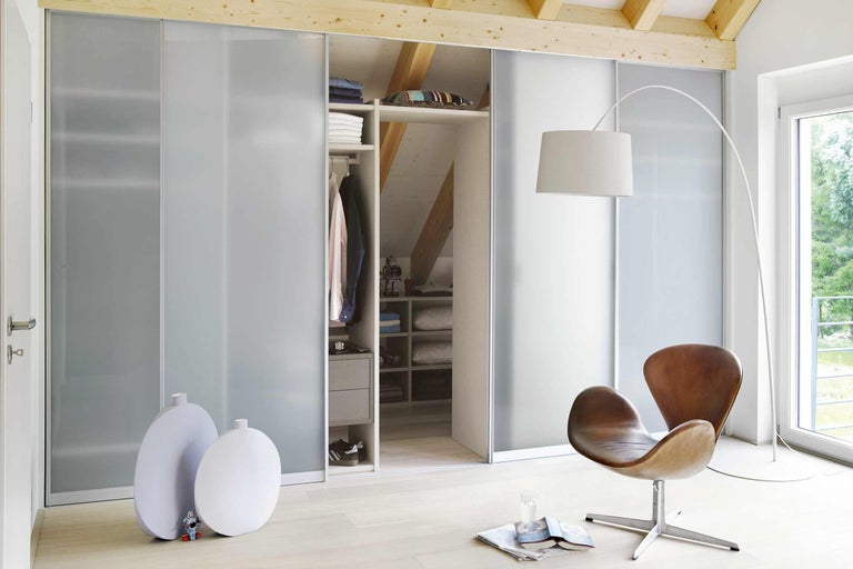 Dressing cu uși glisante în cameră la mansardă cu lampă și fotoliu