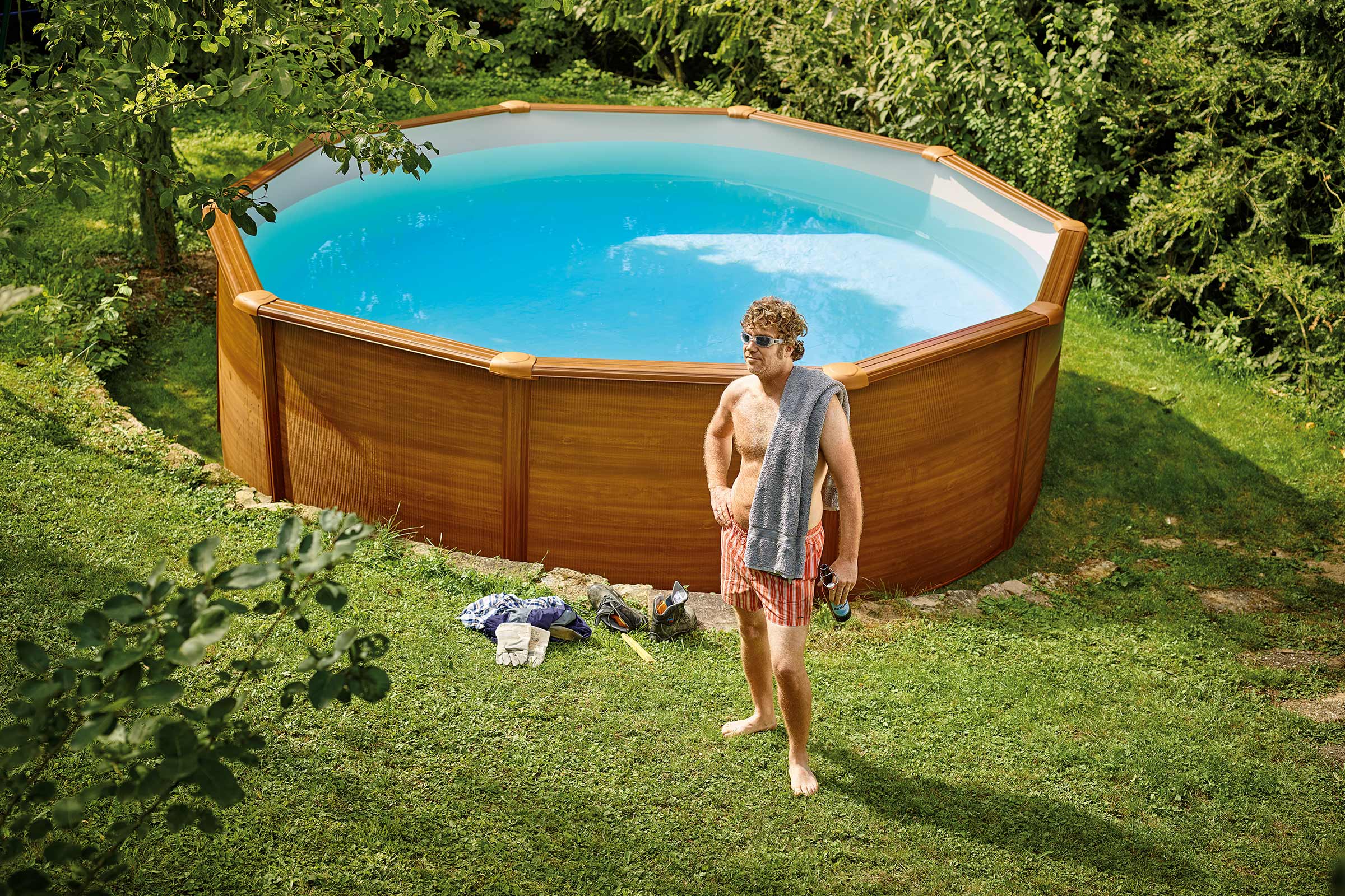 Piscină octogonală în grădină cu o persoană în fața ei