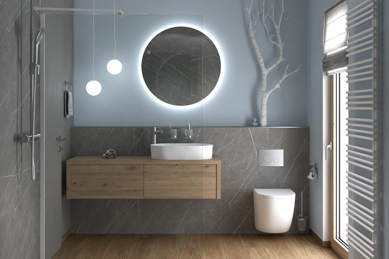 Baie modernă cu mască de chiuvetă cu aspect de lemn, chiuvetă pe blat, oglindă rotundă cu iluminare, toaletă suspendată și duș de tip walk-in.