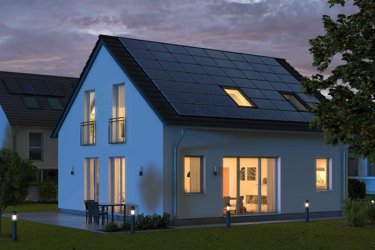 Casă cu sistem solar pe acoperiș la amurg