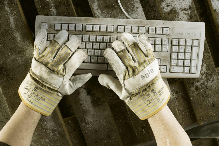 Tastatură murdară și mănuși de lucru pe o scândură de lemn