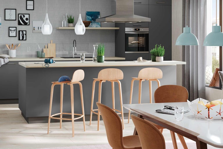 Bucătărie luminoasă cu scaune de bar, masă de sufragerie și aparate moderne