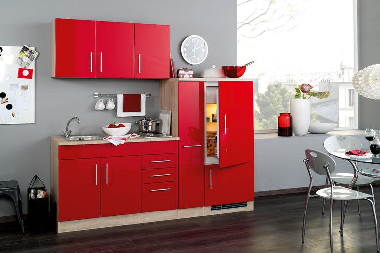 Bucătărie modernă cu dulapuri roșii, chiuvetă și frigider pentru o casă elegantă.