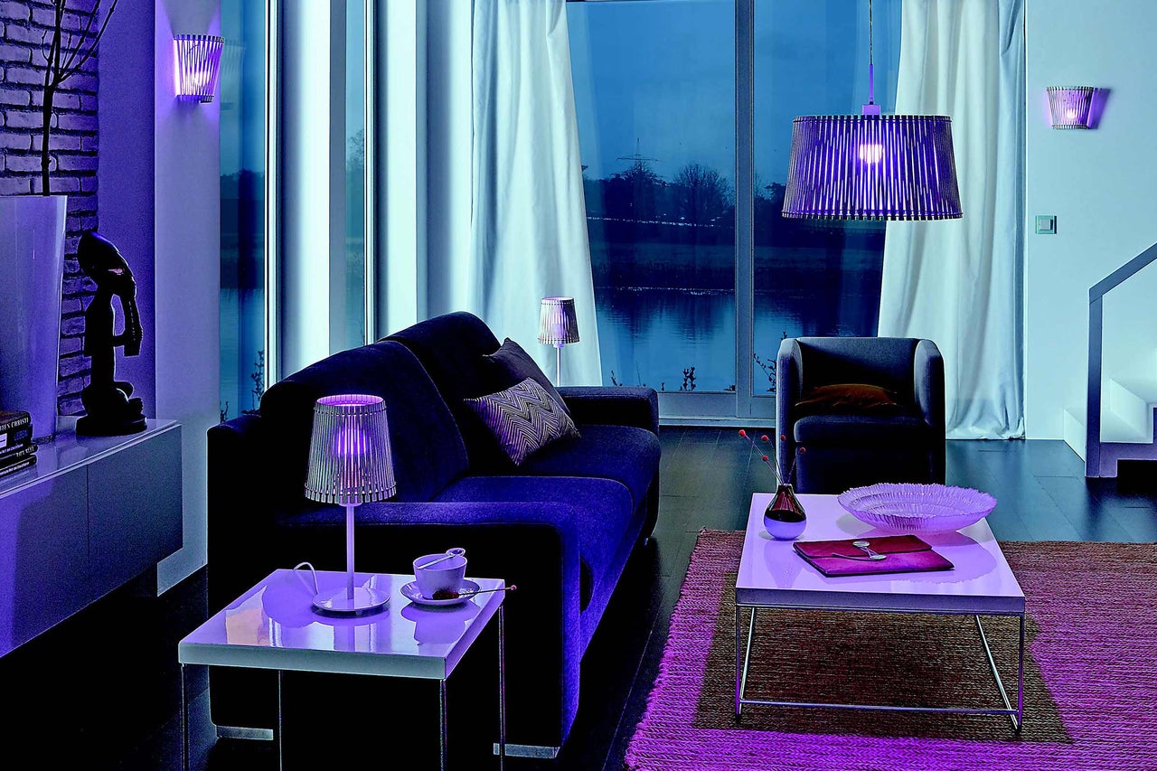 Living cu canapea, fotoliu, măsuță de cafea și diverse lămpi pentru o atmosferă confortabilă