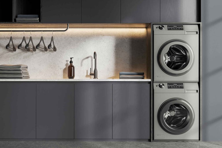 Spălătorie modernă cu mașină de spălat, uscător, chiuvetă și blat de lucru