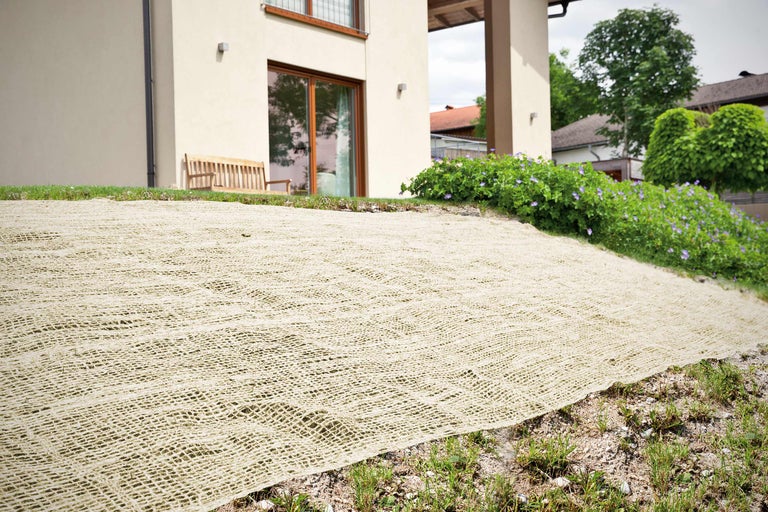 Acoperire de sol din iută pe o zonă verde în fața unei case