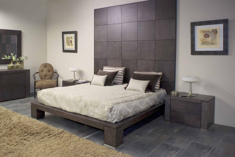 Dormitor cu pat, noptiere, comodă și scaun într-o cameră luminoasă