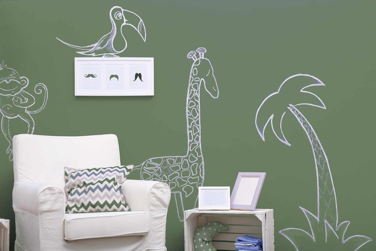 Interior decorativ cu desene cu cretă cu animale pe perete, un fotoliu și obiecte decorative.