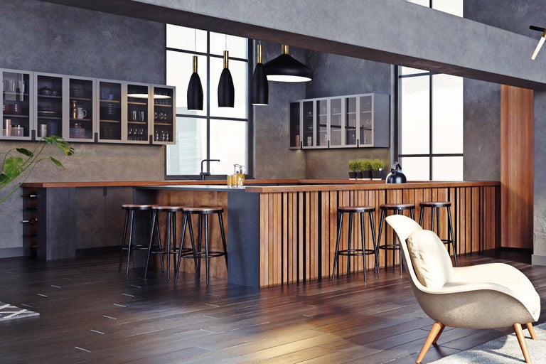 Bucătărie luminoasă cu scaune de bar, corpuri de iluminat suspendate și dulapuri suspendate