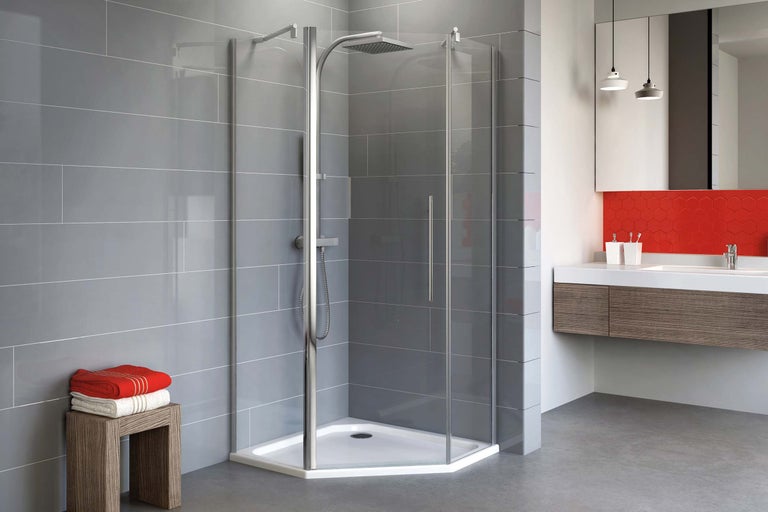 Baie luminoasă cu cabină de duș pe colț, lavoar și plăci de faianță gri.