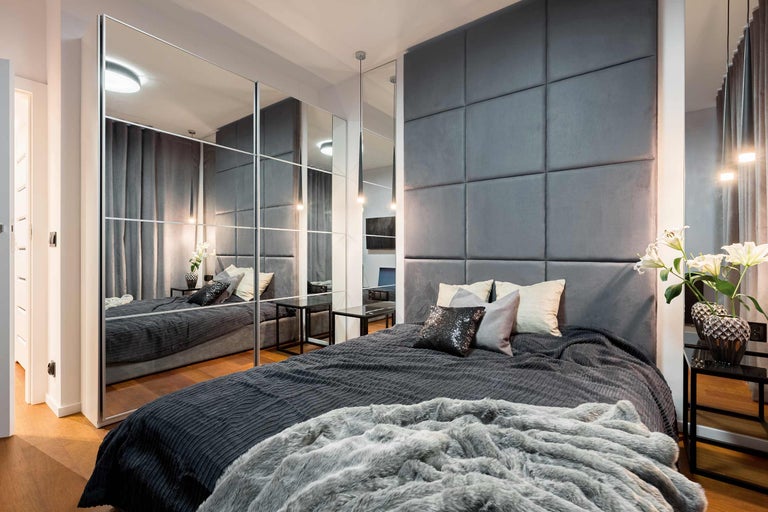 Dormitor modern cu pat, tăblie tapițată și dulap cu oglinzi