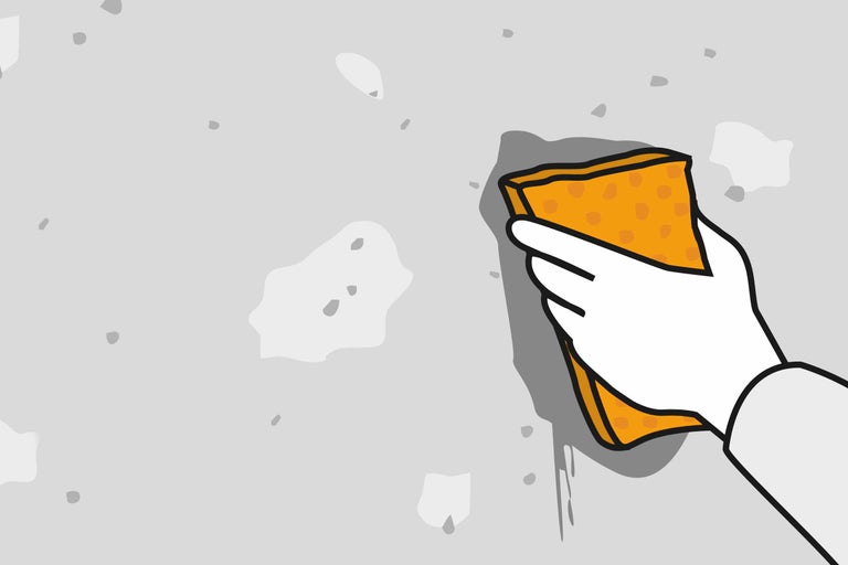 Mână cu burete curăță peretele