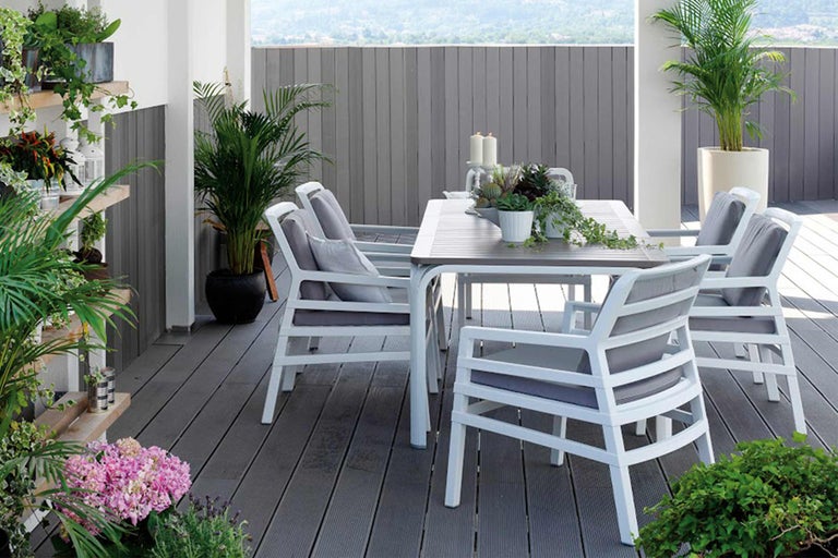 Terasa cu masă de sufragerie, scaune și plante pentru un mediu exterior primitor.