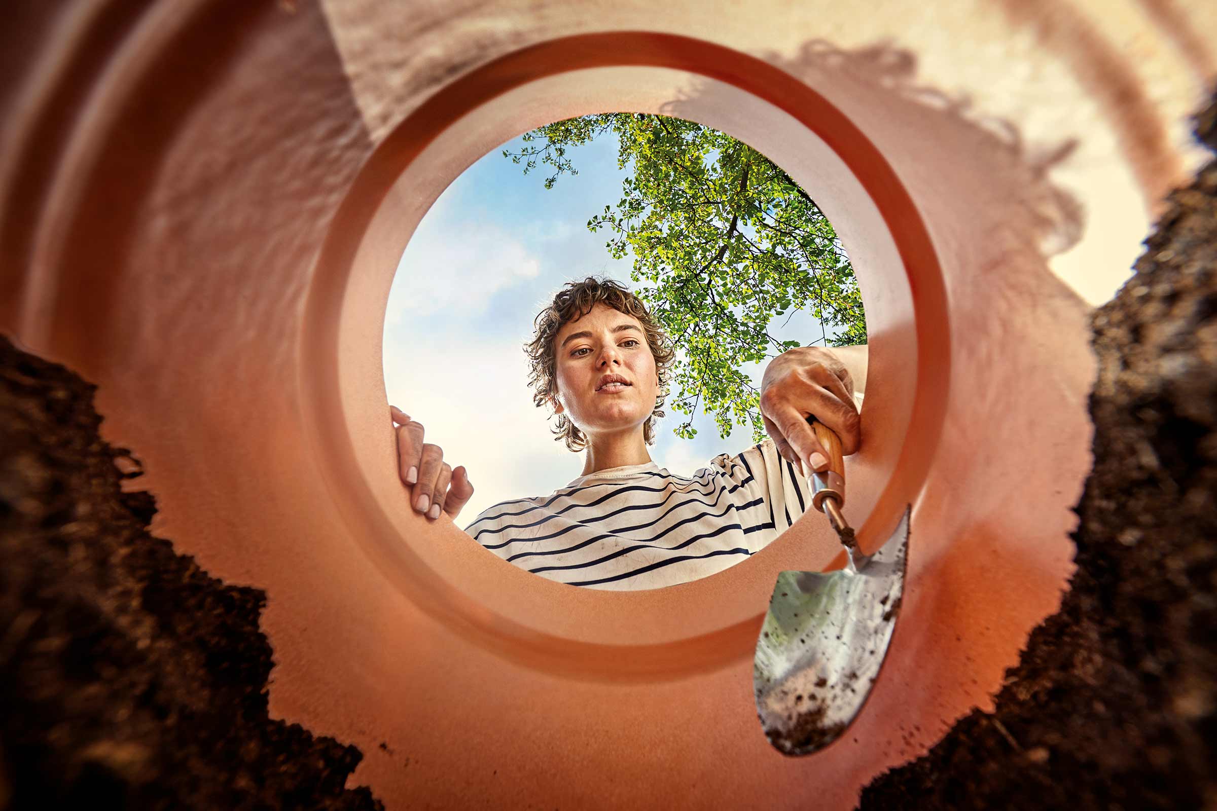 Femeie cu plantator și ghiveci de flori care grădinărește