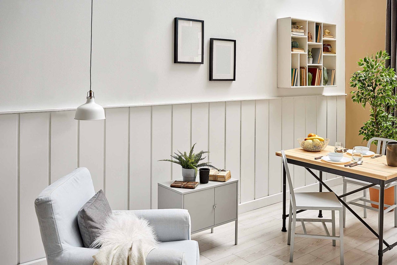 Living luminos cu fotoliu, masă, decorațiuni și raft de perete