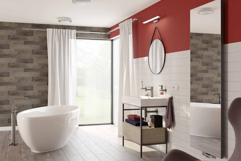 Baie cu cadă independentă, chiuvetă, oglindă și fereastră mare.