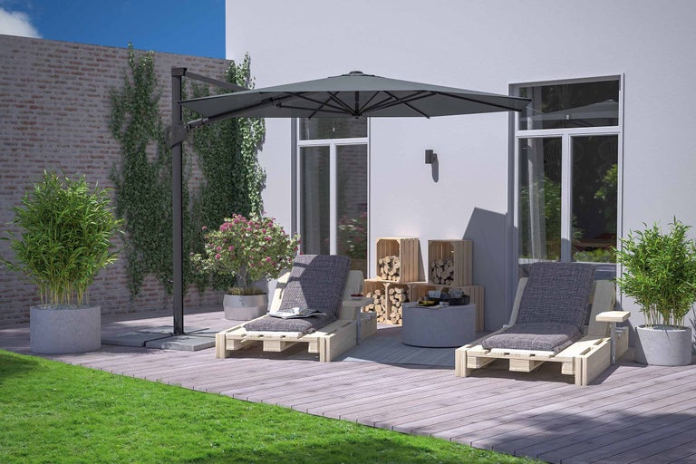 Zonă de grădină cu două șezlonguri din lemn sub o umbrelă de soare care oferă umbră.