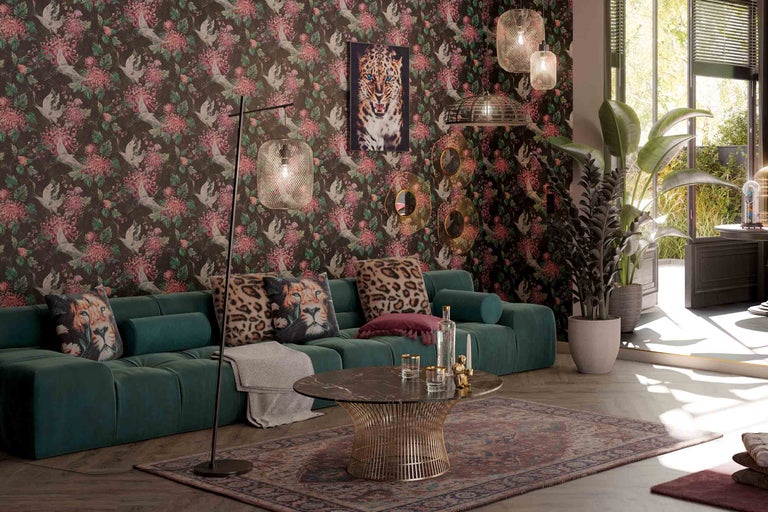 Cameră de zi cu canapea verde, tapet cu model și elemente decorative, cum ar fi perne și lămpi