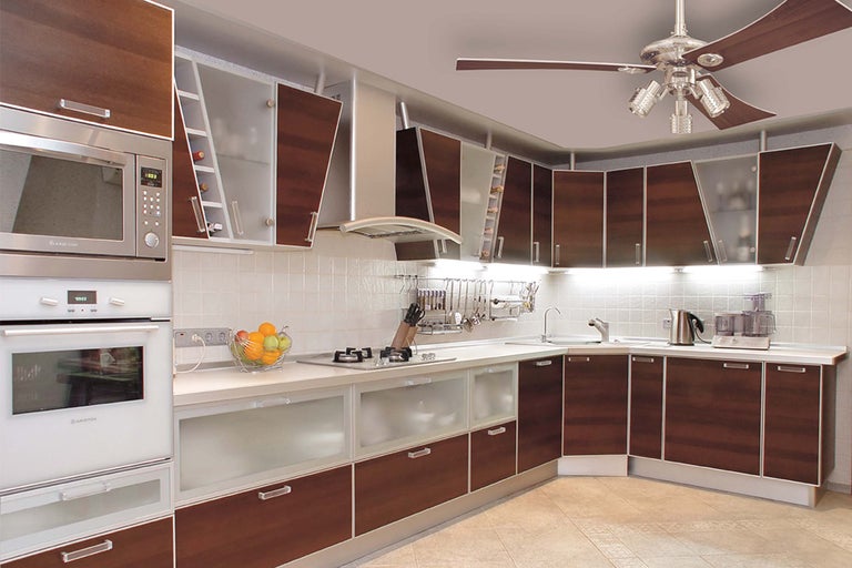 Bucătărie luminoasă cu aparate electrice și dulapuri din lemn