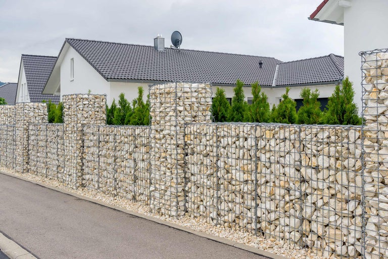 Gard gabion cu pietre în fața unei case