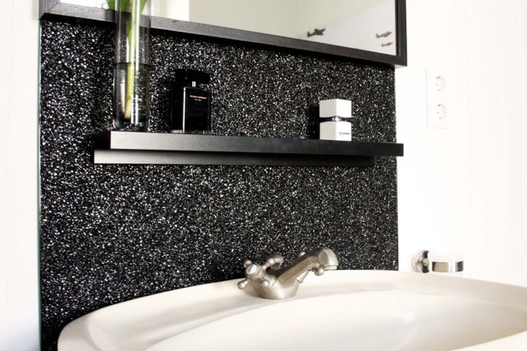 Chiuvetă de baie cu robinet, oglindă și raft de perete în fața unui perete sclipitor