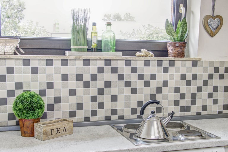 Scenă de bucătărie cu plită, ceainic și articole de decor