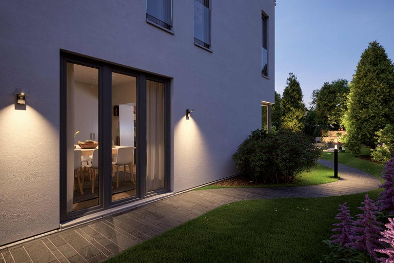 Casă iluminată cu potecă în grădină și lumini exterioare