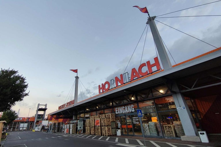Vedere exterioară a unui magazin de bricolaj Hornbach cu intrare și parcare