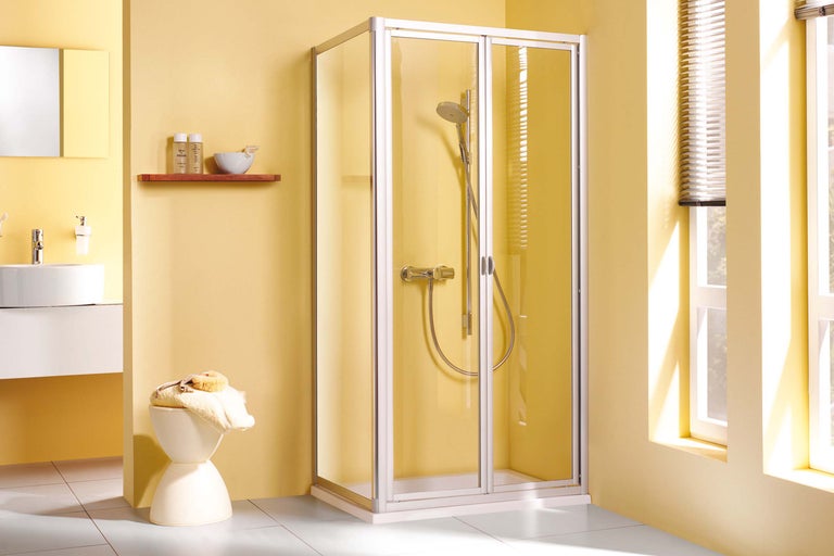 Scenă de baie cu duș cu uși pliante, chiuvetă și accesorii