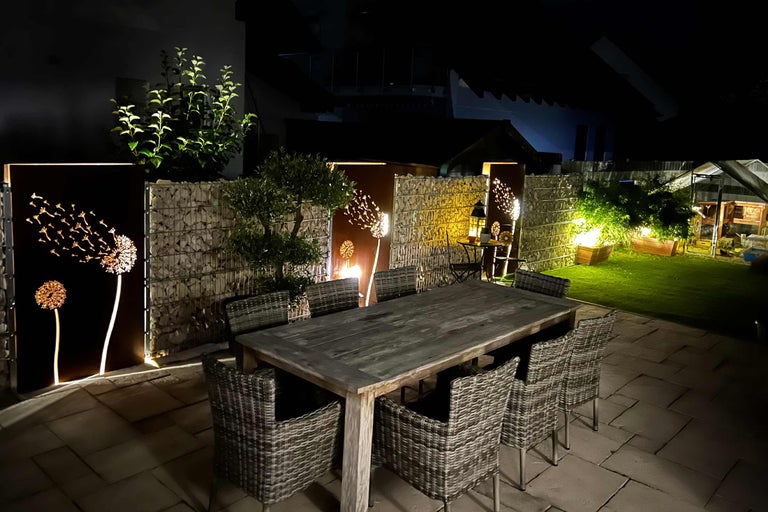 Grădină cu zid de gabioane, masă și scaune