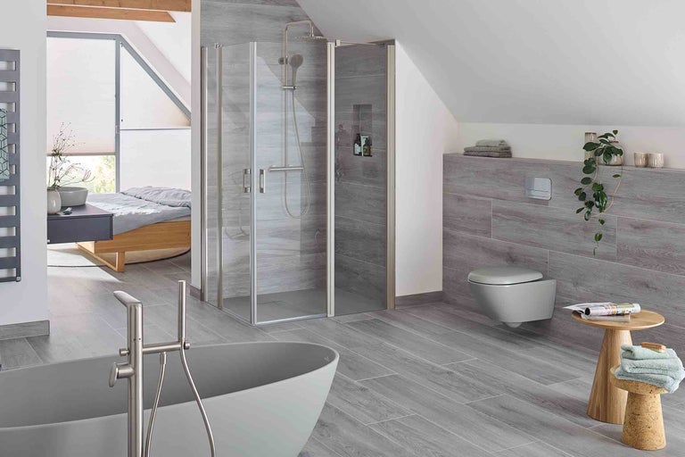 Baie modernă cu duș, cadă, toaletă și podea din lemn