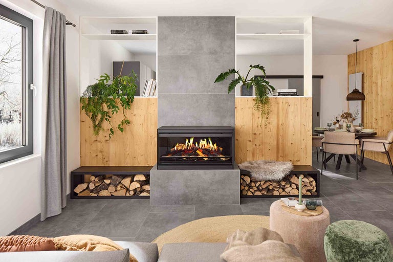 Cameră de zi cu șemineu, depozit de lemne, plante și locuri de ședere pentru o atmosferă confortabilă.