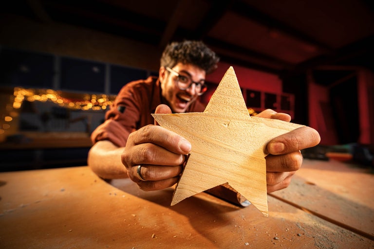 Bărbat ține o stea din lemn în mână