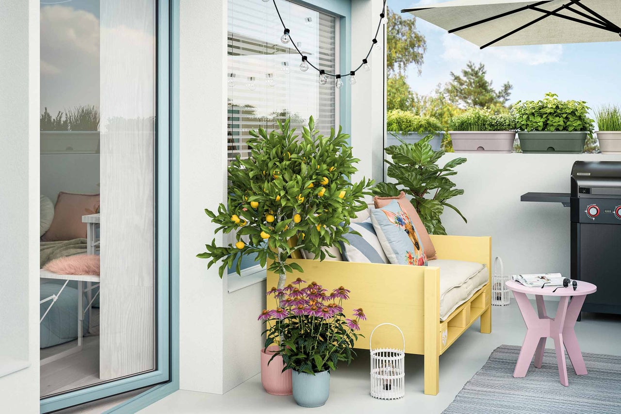 Balcon amenajat cu zonă de relaxare, plante și grătar