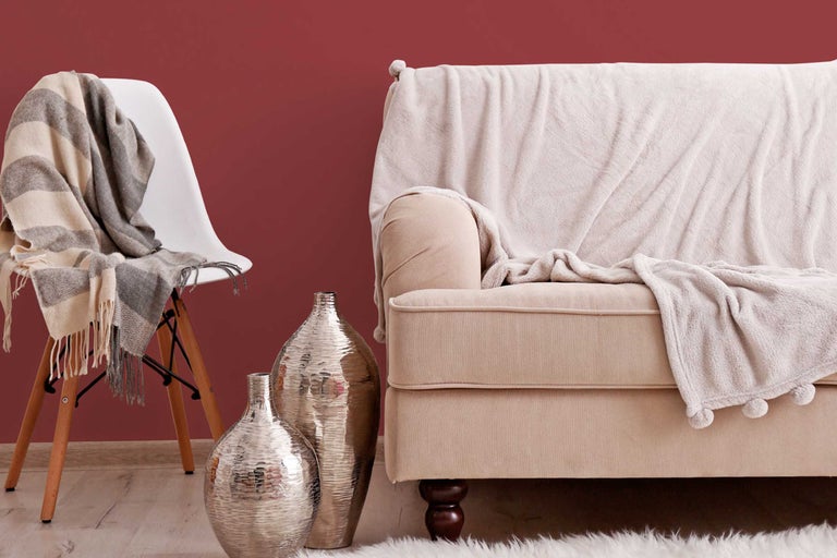 Mediu de locuit decorativ cu canapea, scaun, pături și vaze