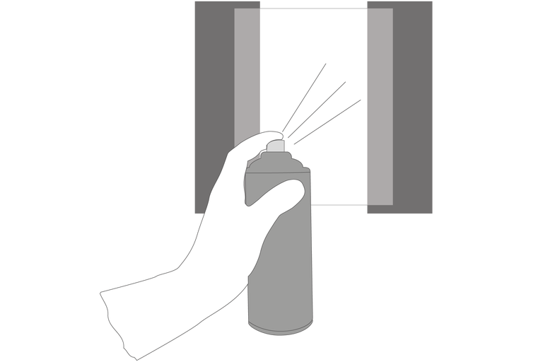 O mână ține un spray în fața unei suprafețe cu bandă adezivă.